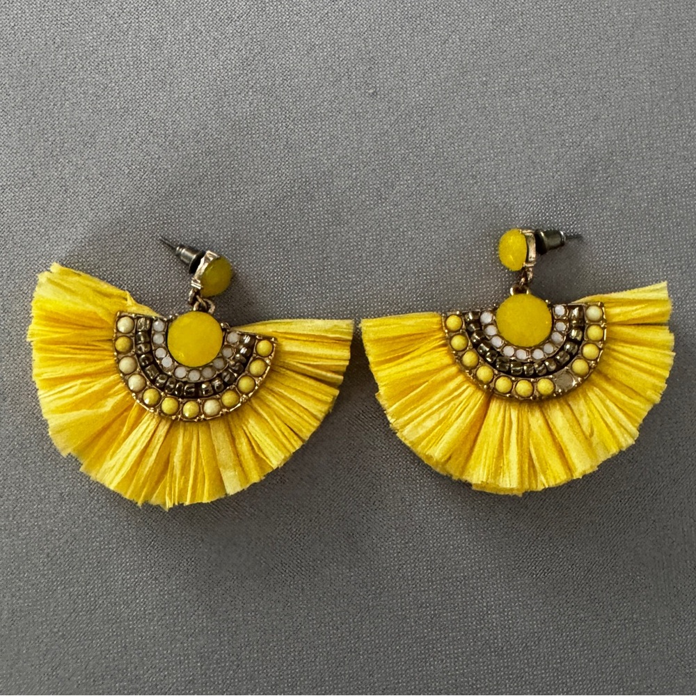 A pair of fun yellow and gold earrings. It has lots of different colored gems.